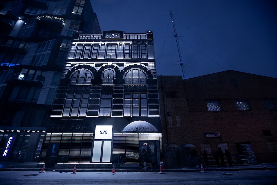 The exterior of the 9:30 Club aglow at night, with snow on the ground and on the window sills. 