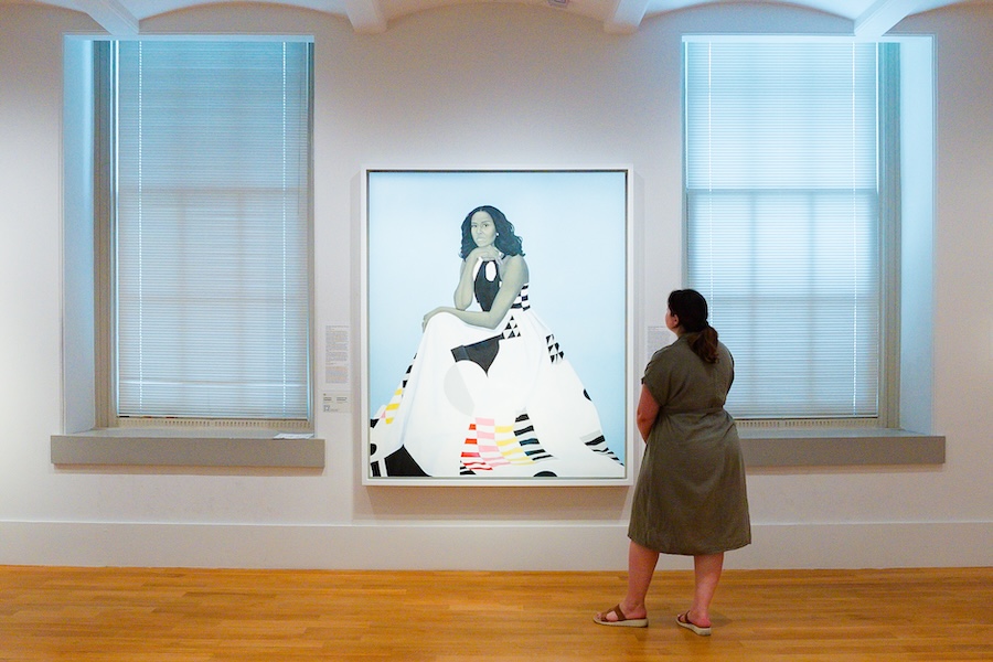 A woman gazes at a stylized portrait of Michelle Obama at the Smithsonian American Art Museum. 