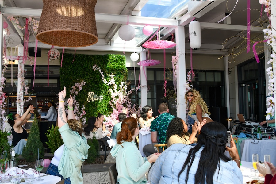A rowdy drag brunch takes place at a bright restaurant. 