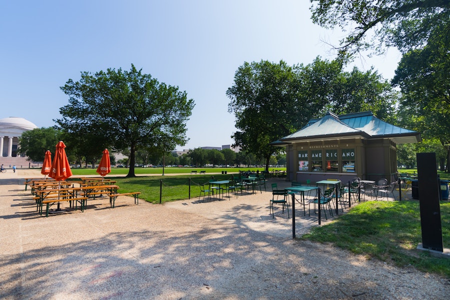 Outdoor tables and umbrellas surround the Bar Americano refreshment kiosk on the National Mall.