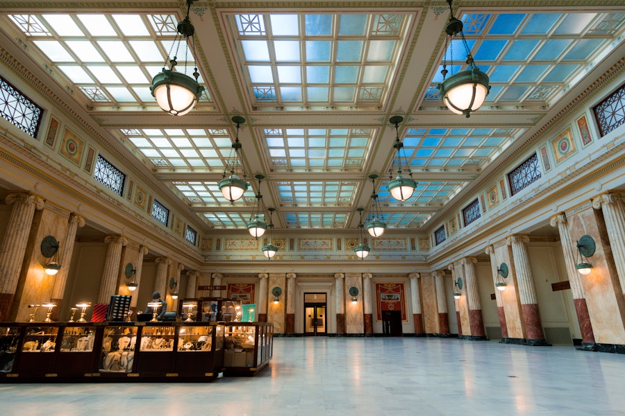 The historic Presidential Suite at Union Station displays ornate decor, marble columns, and a skylit ceiling with art deco details.