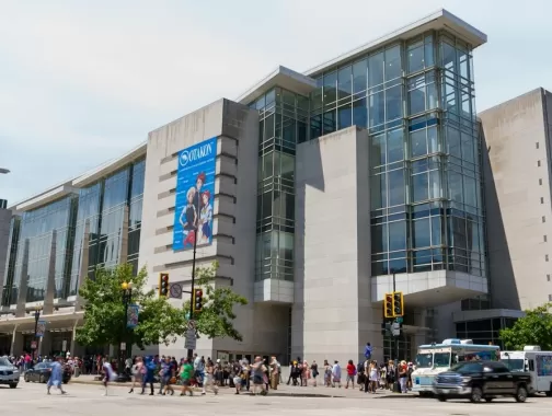 The exterior of the Walter E. Washington Convention Center on a bright day with crowds walking along the street.